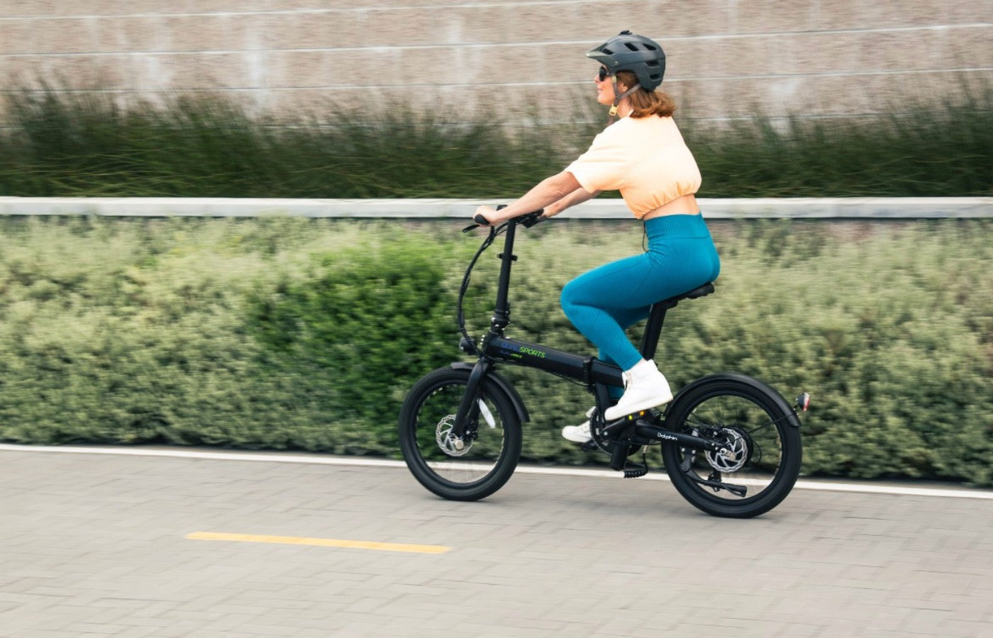 Middle-aged woman riding a dolphin e-bike uphill