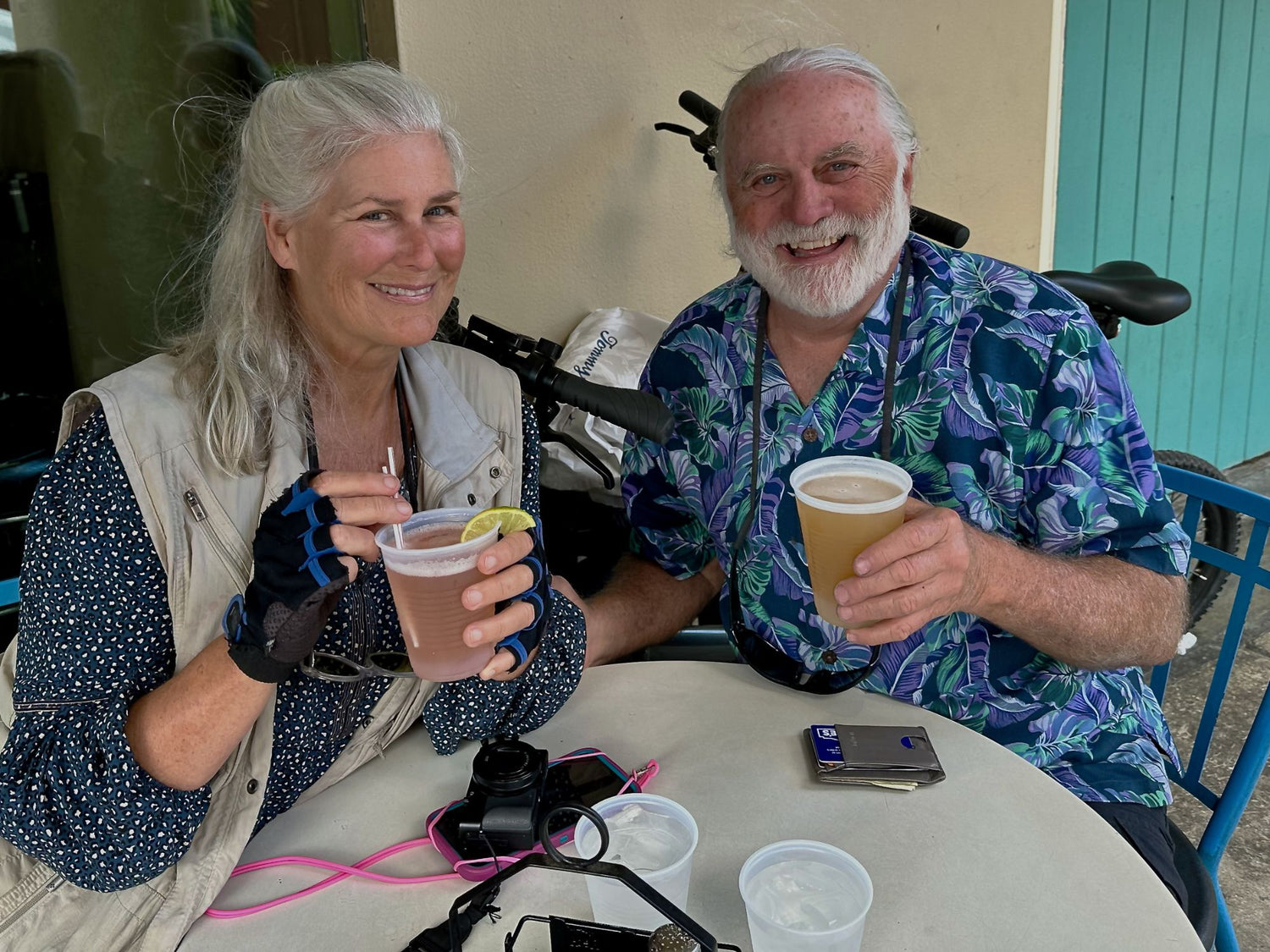 Livinginbeauty traveler with a beverage, behind them is the parked Qualisports Dolphin folding electric bike