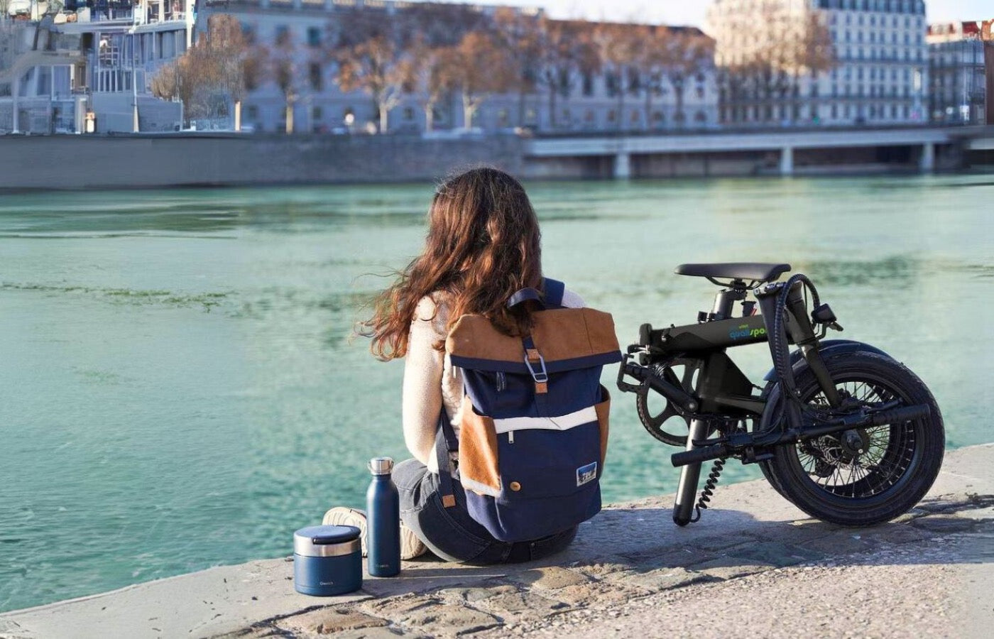 Young girl sitting next to the qualisports nemo folding electric bike