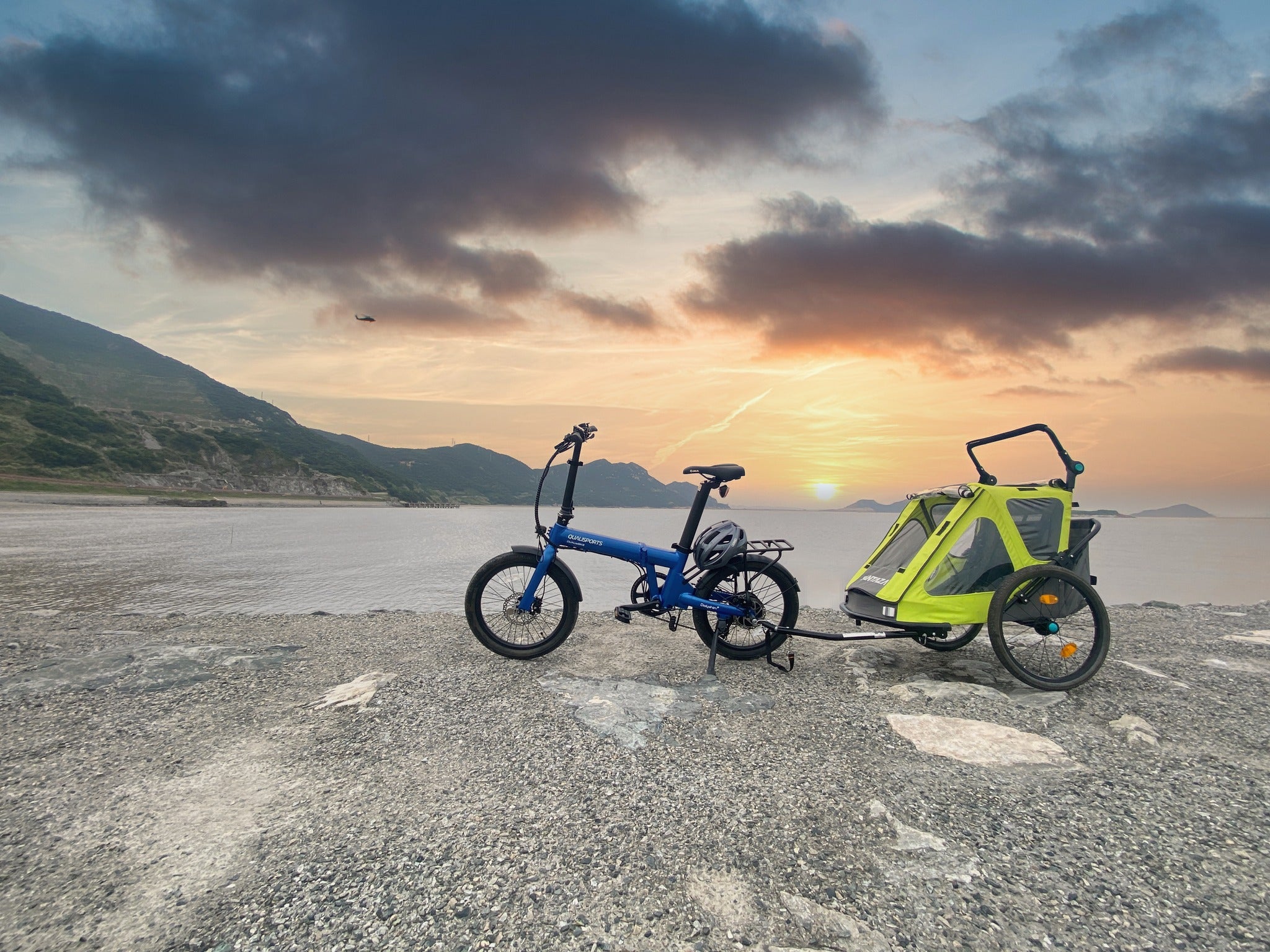 a blue qualisports dolphin ebike with a yellow trailer